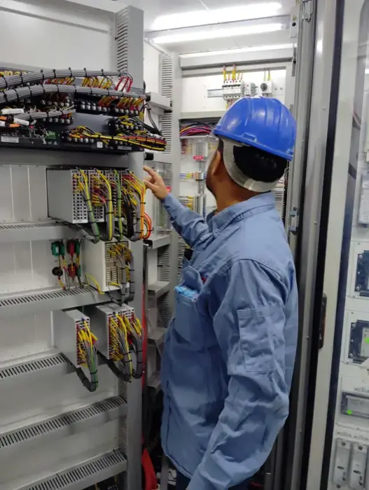 Technicien de maintenance inspectant un tableau électrique industriel